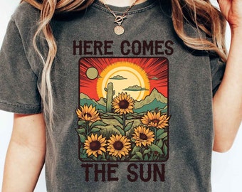 Camiseta "Here Comes The Sun" para amantes de las flores, ideal para viajes a la playa, con un bonito sol, con un toque veraniego, con girasoles, ideal para el verano.