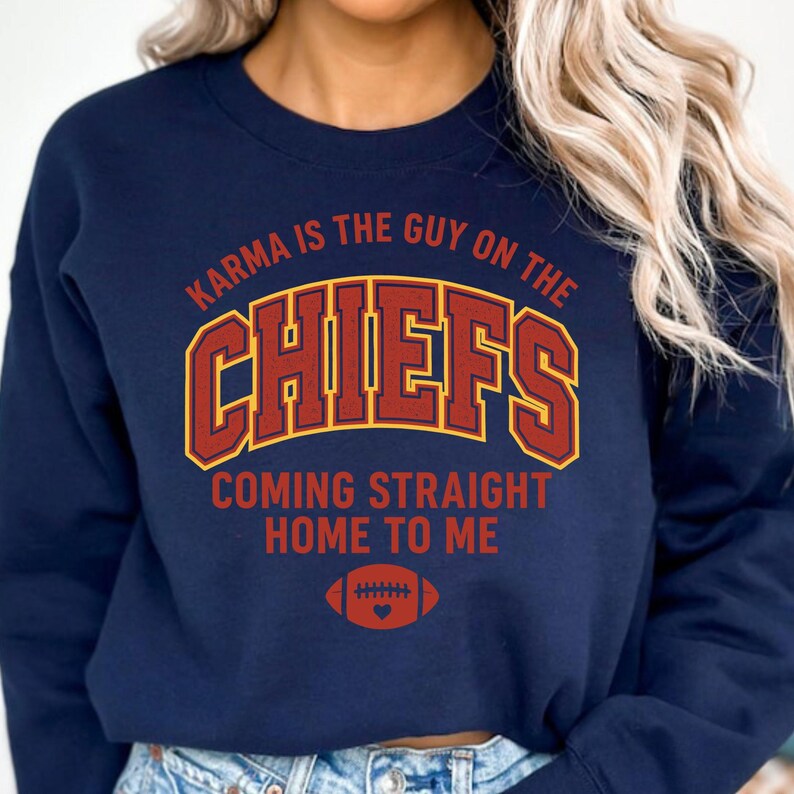 May include: Navy blue sweatshirt with the text "Karma is the Guy on the Chiefs Coming Straight Home to Me." The word "Chiefs" is in a red and gold design, with a football graphic below. A casual top for sports fans.