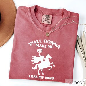 May include: Crimson red t-shirt with a white graphic of a ghost riding a horse and the text "Y'all gonna make me lose my mind".