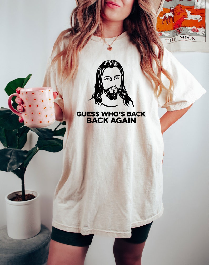 May include: A white t-shirt with a black and white image of Jesus and the text "Guess who's back back again".