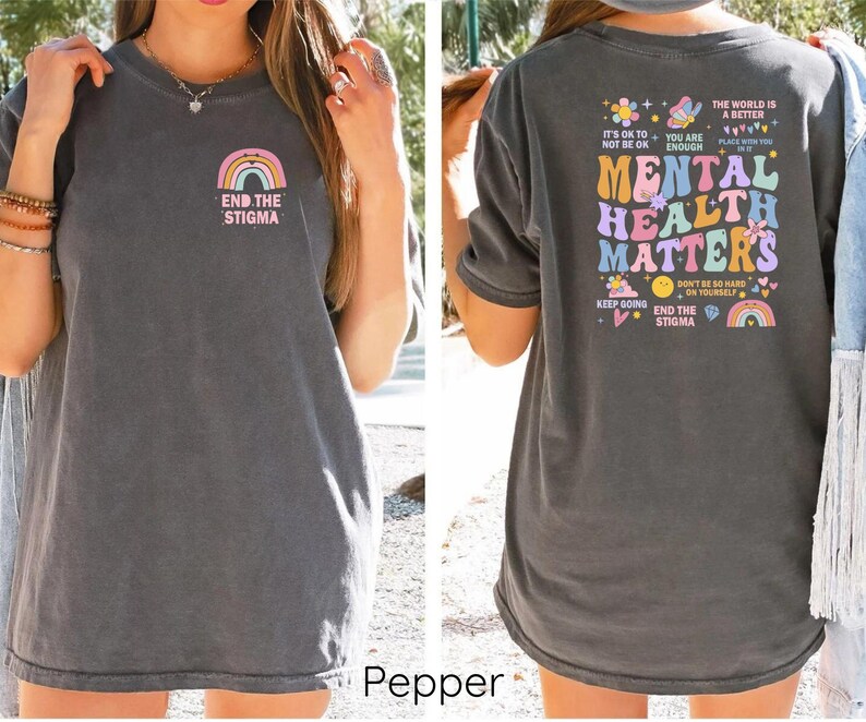 May include: A gray t-shirt with a rainbow and the text "End the Stigma" on the front. The back of the shirt has a colorful graphic with the text "Mental Health Matters" and other phrases about mental health.