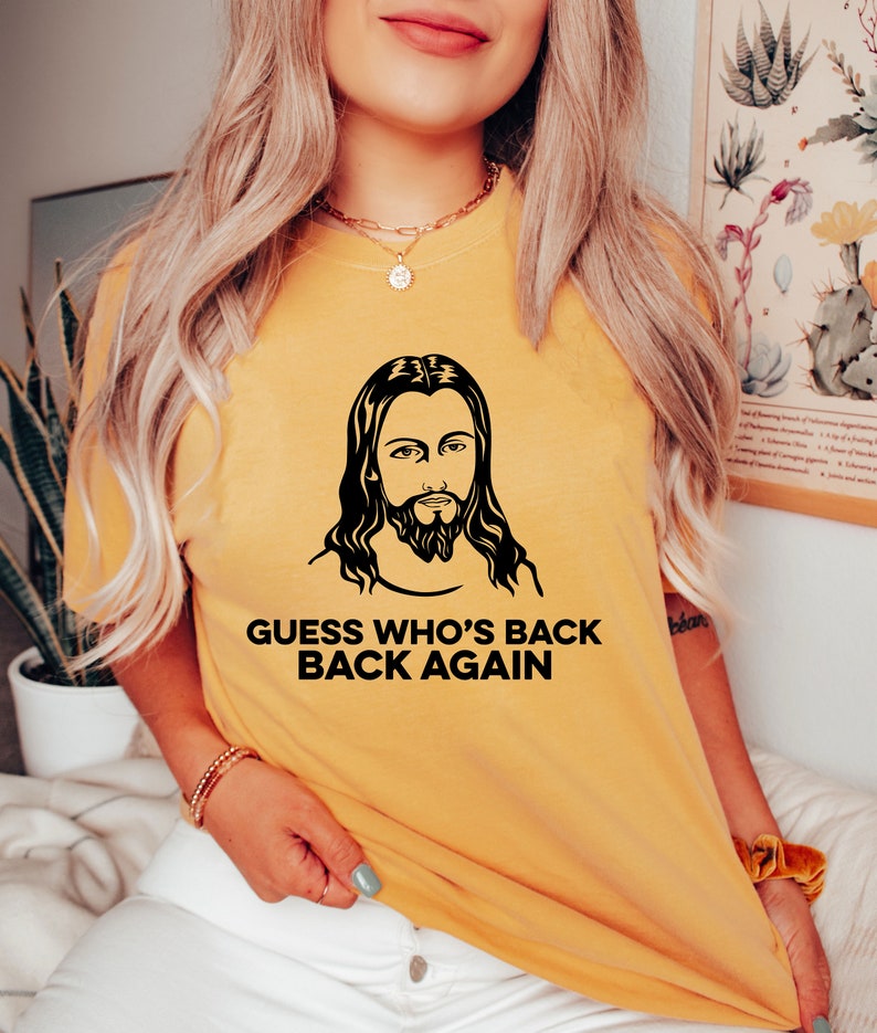 May include: A yellow t-shirt with a black and white image of Jesus and the text "Guess who's back back again".