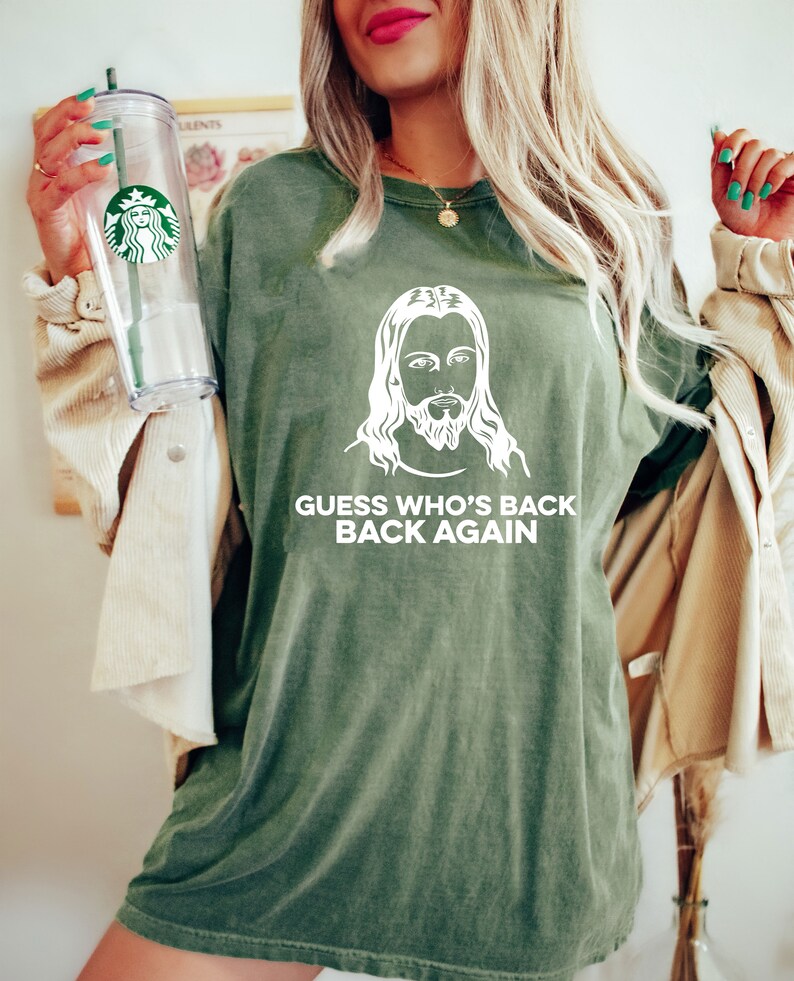 May include: Green t-shirt with a white image of Jesus and the text "GUESS WHO'S BACK BACK AGAIN".