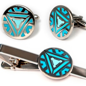 May include: A set of silver cufflinks and a tie clip featuring a blue and silver Iron Man symbol.