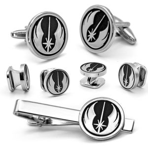 May include: A silver cufflink set featuring the Rebel Alliance symbol from Star Wars. The set includes two cufflinks, two shirt studs, and a tie bar.