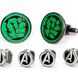 Peut inclure: Un ensemble de boutons de manchette et de cravate avec le poing du Hulk et le logo 'A' des Avengers. Les boutons de manchette sont en argent avec un design en émail vert et noir. Les attaches de cravate sont en argent avec un design en émail noir.