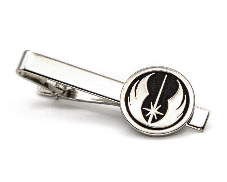 May include: A silver tie clip featuring a black and silver Rebel Alliance symbol.
