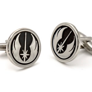 May include: A pair of silver cufflinks featuring a black and white Rebel Alliance symbol.