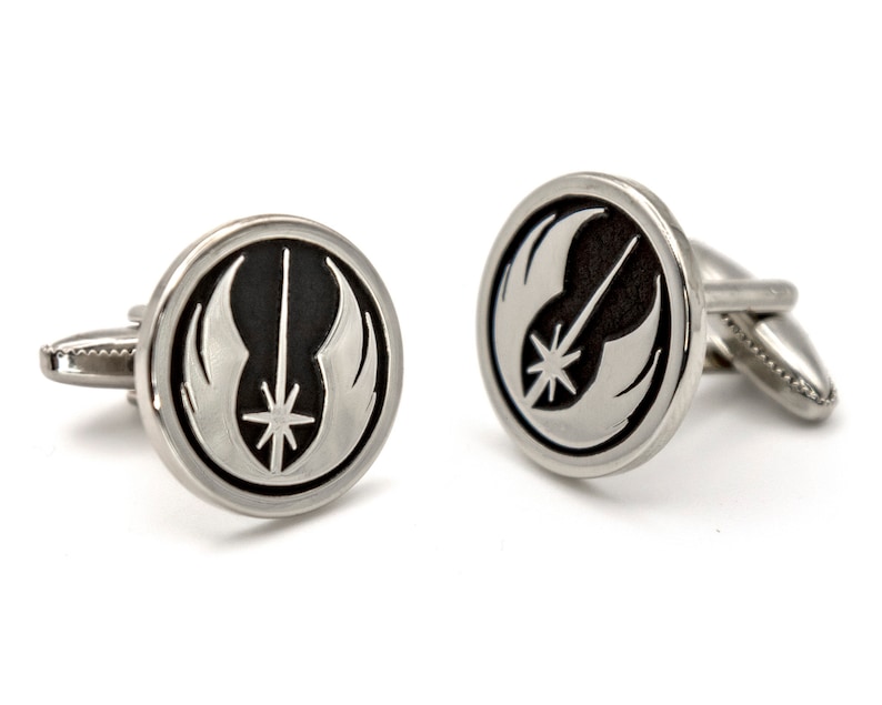 May include: A pair of silver cufflinks featuring a black and white Rebel Alliance symbol.