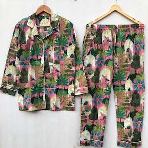 Pu&ograve; includere: Un pigiama rosa e verde con una stampa floreale che presenta pavoni ed edifici. Il set comprende una camicia a maniche lunghe con bottoni e pantaloni abbinati.