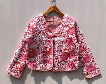 May include: A pink and white floral print quilted jacket with a V-neck and long sleeves. The jacket has a button closure and a pocket on the left side. The text "Wishtexelle" is visible on the front of the jacket.