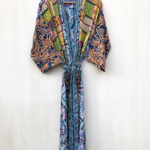 May include: A blue and orange patterned silk robe with a sash tie. The robe has a patchwork design with floral and geometric patterns.
