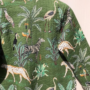 May include: A green quilted jacket with a tropical print featuring zebras, leopards, flamingos, toucans, and palm trees.