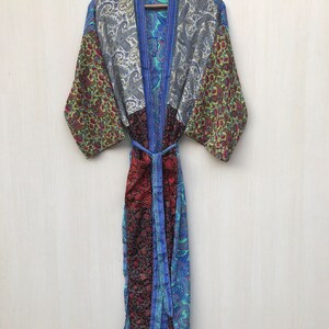 Könnte beinhalten: Eine blaue, grüne und rote gemusterte Seidenrobe mit einem Gürtel. Die Robe ist aus Patchwork-Stoff gefertigt und hat einen traditionellen japanischen Kimono-Stil.