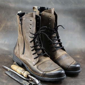 May include: A pair of brown leather boots with black laces and a zipper on the side. The boots have a rugged look and are made of high-quality leather.