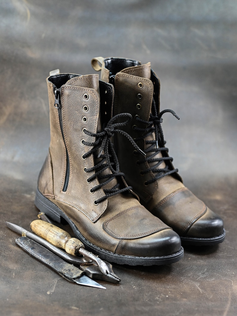 May include: A pair of brown leather boots with black laces and a zipper on the side. The boots have a rugged look and are made of high-quality leather.