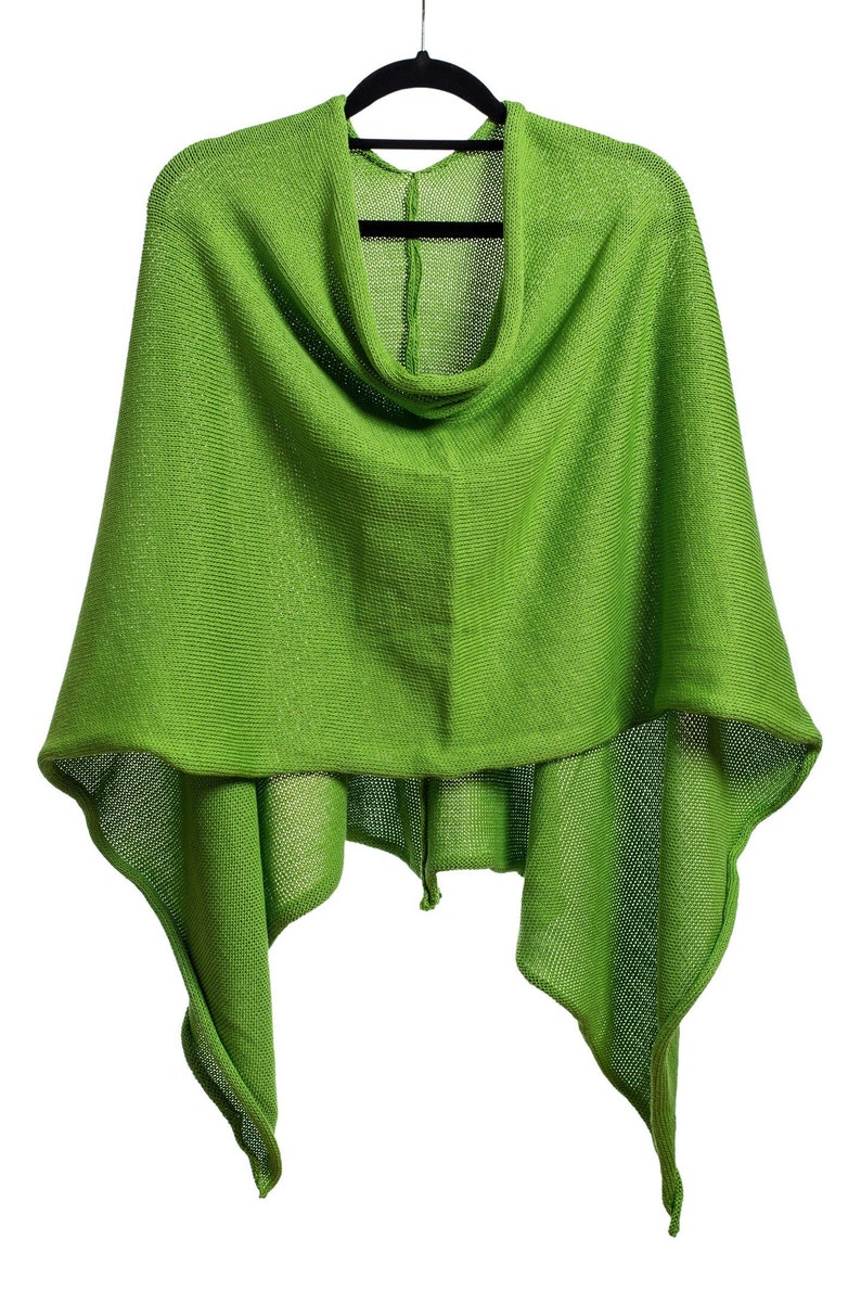 May include: A green knitted poncho with a cowl neck and a loose fit.