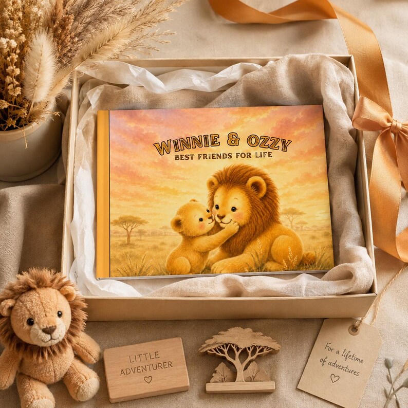 May include: A rectangular book titled Winnie & Ozzy Best Friends For Life featuring an illustration of a lion cub and an adult lion in a savanna, accompanied by a plush lion toy, a wooden block with text, a wooden tree cutout, and a gift tag.