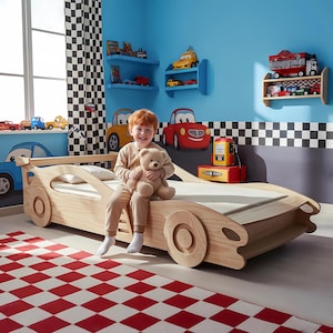 May include: A light-coloured wooden race car bed with integrated wheel designs on the side panels and a rear spoiler. The bed frame features a low-profile structure with smooth, curved cutouts along the sides, designed to resemble a sports car chassis.