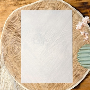 May include: A blank white sheet of paper on a wooden slice with a natural wood grain pattern.