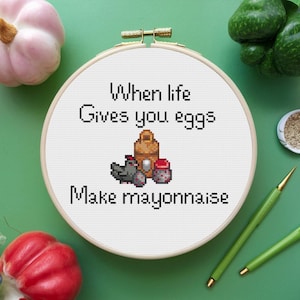 Może przedstawiać: Biały tamborek do haftu z czarno-białym pikselowanym obrazkiem kurczaka, jajek i słoika majonezu. Tekst "When life gives you eggs make mayonnaise" jest napisany czarnym kolorem.