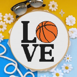 Op de afbeelding: Wit canvas met het woord "LOVE" in zwarte letters met een basketbal in het midden van het woord. De basketbal is oranje met zwarte lijnen.