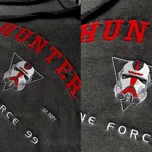 May include: Dark gray hoodie with red embroidered text reading "HUNTER" and a white and red helmet design. The text "VE FORCE" and numbers are also embroidered in white. The hoodie has a drawstring hood.