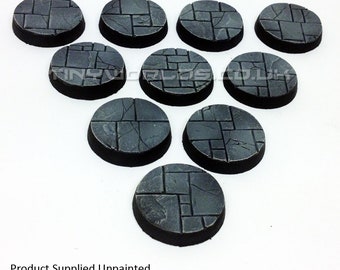 May include: A collection of ten unpainted, circular bases for miniature figures. Each base features a textured, stone-like surface with a dark gray color and a black rim. The bases are arranged in a fan shape. The text "Product Supplied Unpainted" is visible.