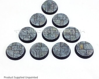 May include: A collection of ten unpainted, circular miniature bases. Each base features a stone-like texture with a dark rim. The bases are arranged in a triangular pattern against a white background. The text "Product Supplied Unpainted" is visible.