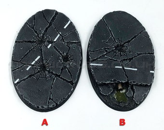 May include: Two oval, unpainted miniature bases with a cracked asphalt design. White road lines are painted on the dark gray surface. The bases are labeled A and B. The text "Product Supplied Unpainted" is at the bottom.