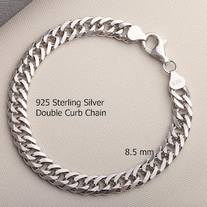 May include: A 925 sterling silver double curb chain bracelet with a lobster claw clasp. The metal links are polished and reflective. The text 925 Sterling Silver Double Curb Chain and 8.5 mm is printed on the image. The clasp is stamped 925.