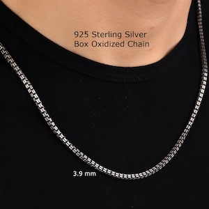 May include: A 925 sterling silver box oxidized chain with a dark, metallic finish. The chain features a square-link design and measures 3.9 mm in width. The text 925 Sterling Silver Box Oxidized Chain and 3.9 mm are visible on the image.