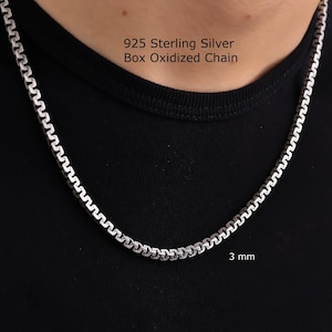 May include: A 3 mm 925 Sterling Silver Box Oxidized Chain. The necklace features a series of interconnected square-shaped links with a dark, oxidized finish in the recessed areas, creating a distinct contrast against the polished silver surfaces.