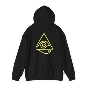 Peut inclure: Sweat-shirt à capuche noir avec un motif de triangle et d'œil jaune au dos.