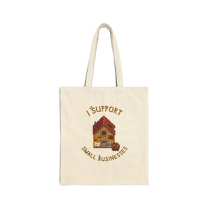 May include: A beige tote bag with a brown house illustration and the text "I support small businesses".