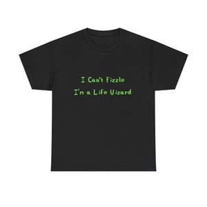 May include: Black t-shirt with the text "I Can't Fizzle I'm a Life Wizard" in green. The shirt is a crew neck style, and the text is centered on the front. The shirt is made of a soft material.