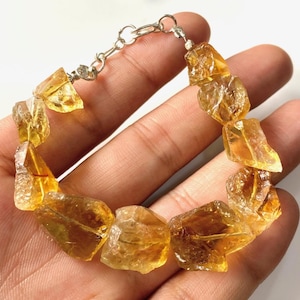 Op de afbeelding: Een armband gemaakt van ruwe, gefacetteerde, gele citrien stenen. De armband is geregen op een zilveren ketting met een karabijn sluiting.