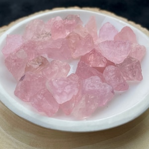 Puede incluir: Una colecci&oacute;n de cristales de cuarzo rosa de diferentes tama&ntilde;os y formas. Los cristales est&aacute;n pulidos y tienen un acabado liso y brillante.