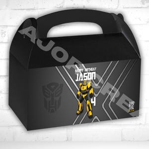 May include: Black gable box with a handle, featuring a Transformers theme. The box has a gray background with a Bumblebee character illustration, the name "JASON", and the number "4". The text "HAPPY BIRTHDAY" is also visible.