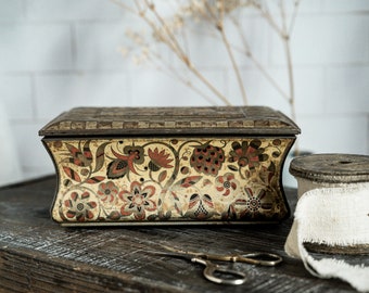 Tin with rounded sides, gold/red colored with bird on lid