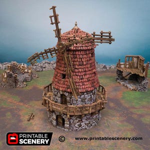 May include: A miniature windmill model featuring a stone-textured base, a red shingled conical roof, and wooden blades. The structure includes a wooden balcony encircling the midsection and two smaller stone ruin structures nearby. Text reads PRINTABLE SCENERY.