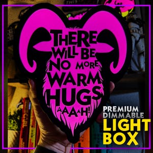 May include: A black light box in the shape of a ram's head with the text "THERE WILL BE NO MORE WARM HUGS" in white and pink. The light box also has the text "PREMIUM DIMMABLE LIGHT BOX".