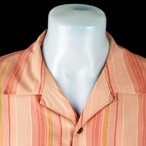 May include: A pink and green striped button-down shirt with a collar.