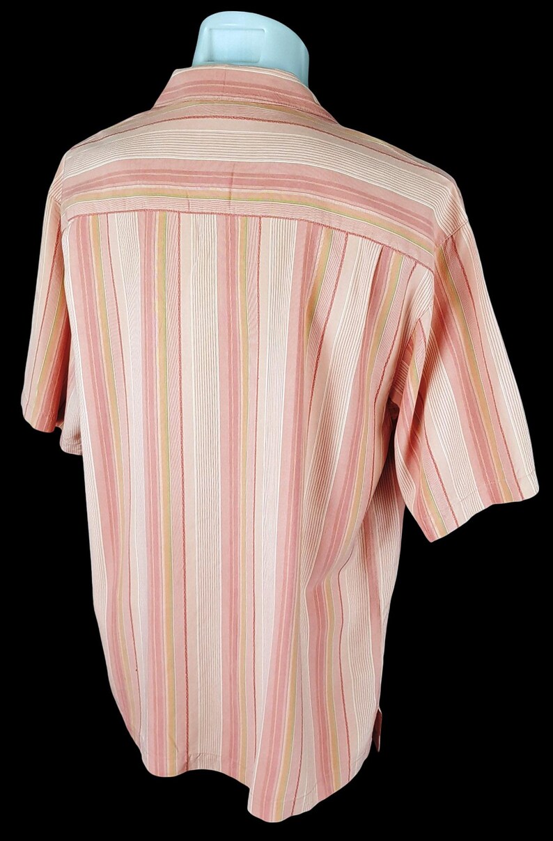 May include: A pink and beige striped short-sleeved button-down shirt.