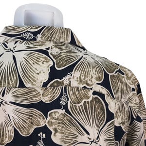 Peut inclure: Gros plan d'une chemise boutonn&eacute;e avec un grand motif floral. La chemise pr&eacute;sente de grandes fleurs stylis&eacute;es dans des tons beige et marron sur un fond bleu marine fonc&eacute;. Le col et le dos de la chemise sont visibles.