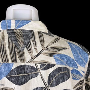 May include: A white shirt with a blue and brown leaf pattern. The shirt is made of a soft, textured fabric.