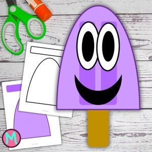 May include: A purple popsicle-shaped craft with a smiling face, large white-rimmed eyes, and a wooden stick. Craft supplies include scissors, glue stick, and printed paper templates, all on a light wood-grain surface.
