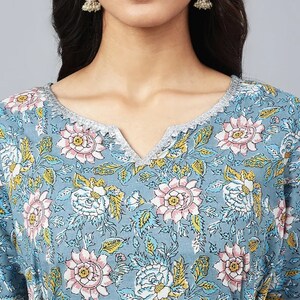 May include: A blue floral print top with a V-neck and a silver trim around the neckline.
