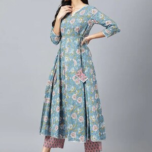 May include: A blue floral print dress with a tie at the waist and matching pink pants. The dress has a V-neck and three-quarter sleeves.