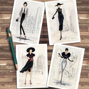 Könnte beinhalten: Vier Modeillustrationsdrucke mit Frauen in stilvollen Outfits vor Stadtkulissen. Die Drucke zeigen eine Vielzahl eleganter Kleidung, darunter Kleider, Hüte und Accessoires. Ein grüner und roségoldener Stift liegt auf einer Holzoberfläche.